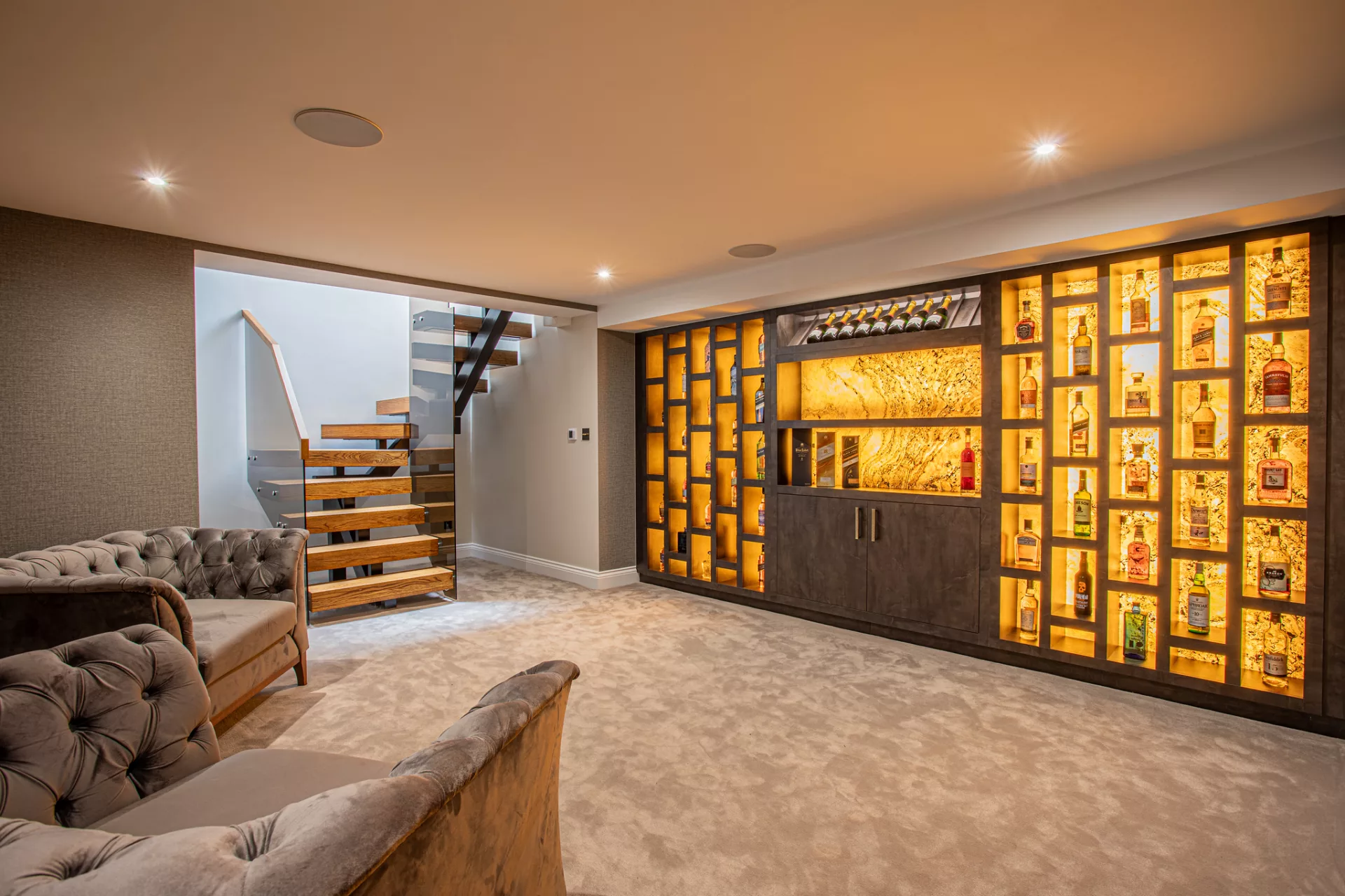 a bespoke back lit stone whiskey wall to create a boutique Mayfair Gentleman's club feel. 